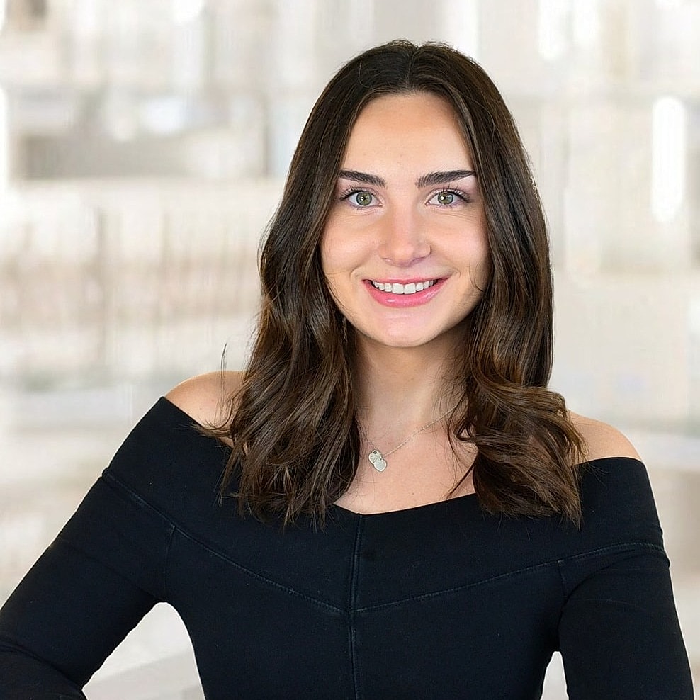 Smiling woman in off-shoulder black top.