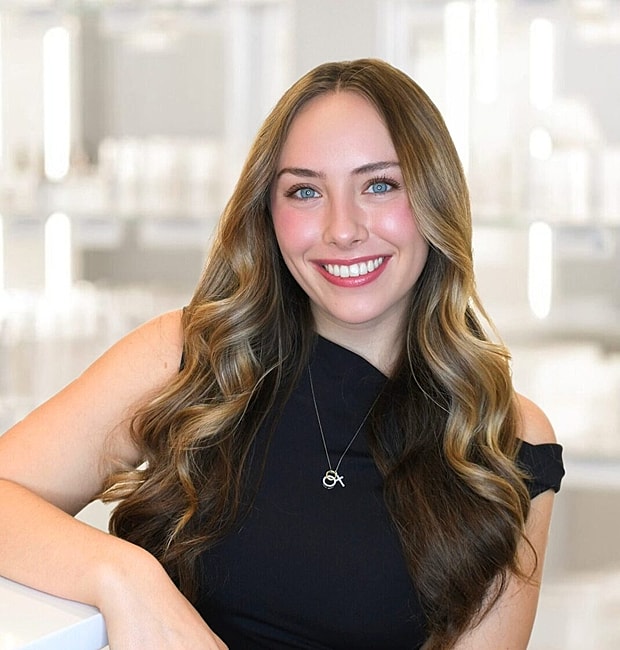 Smiling woman with long hair in modern setting.