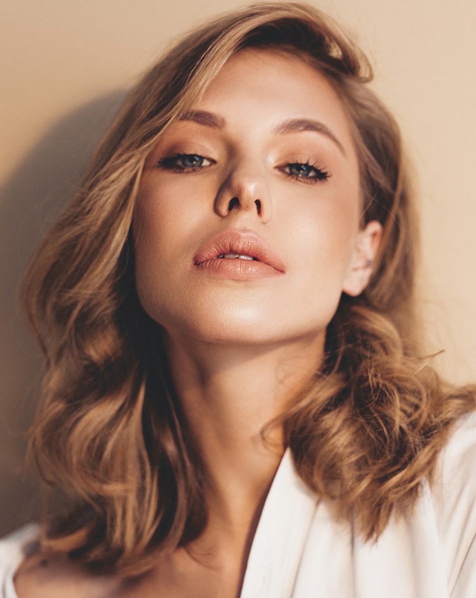 Woman with styled hair and natural makeup.