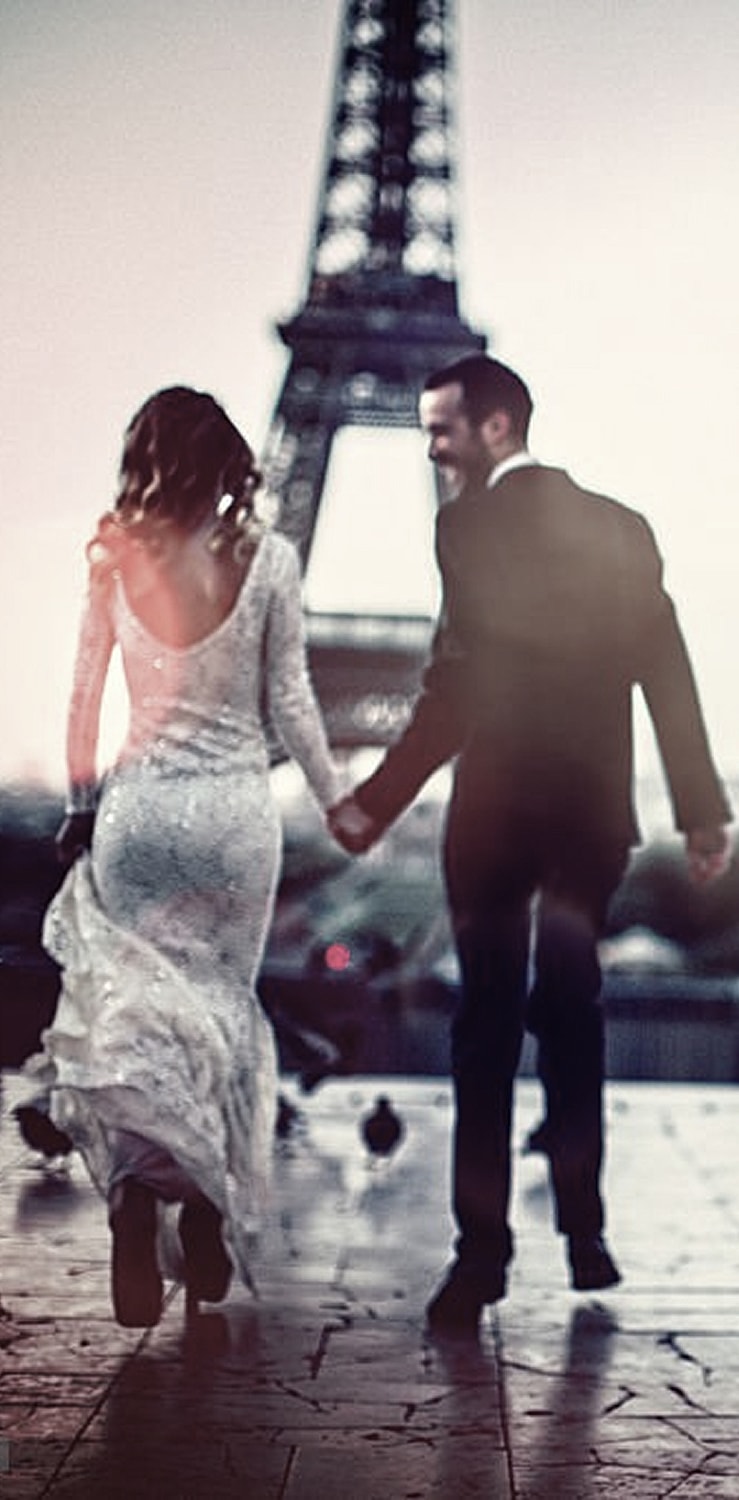Three women in white lab coats smiling indoors.
